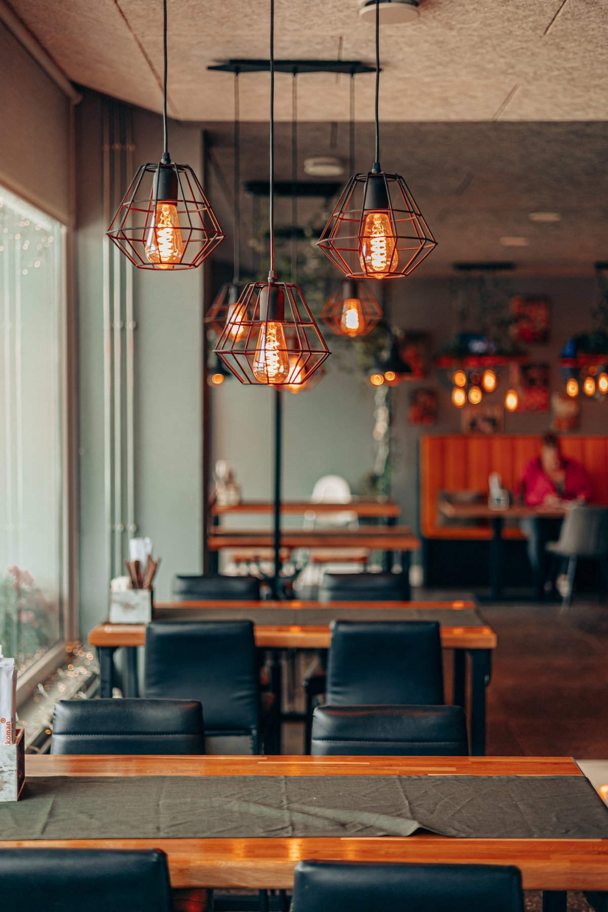 Taberna cálida de madera con iluminación edison que ilustra un soporte QR con estilo tradicional