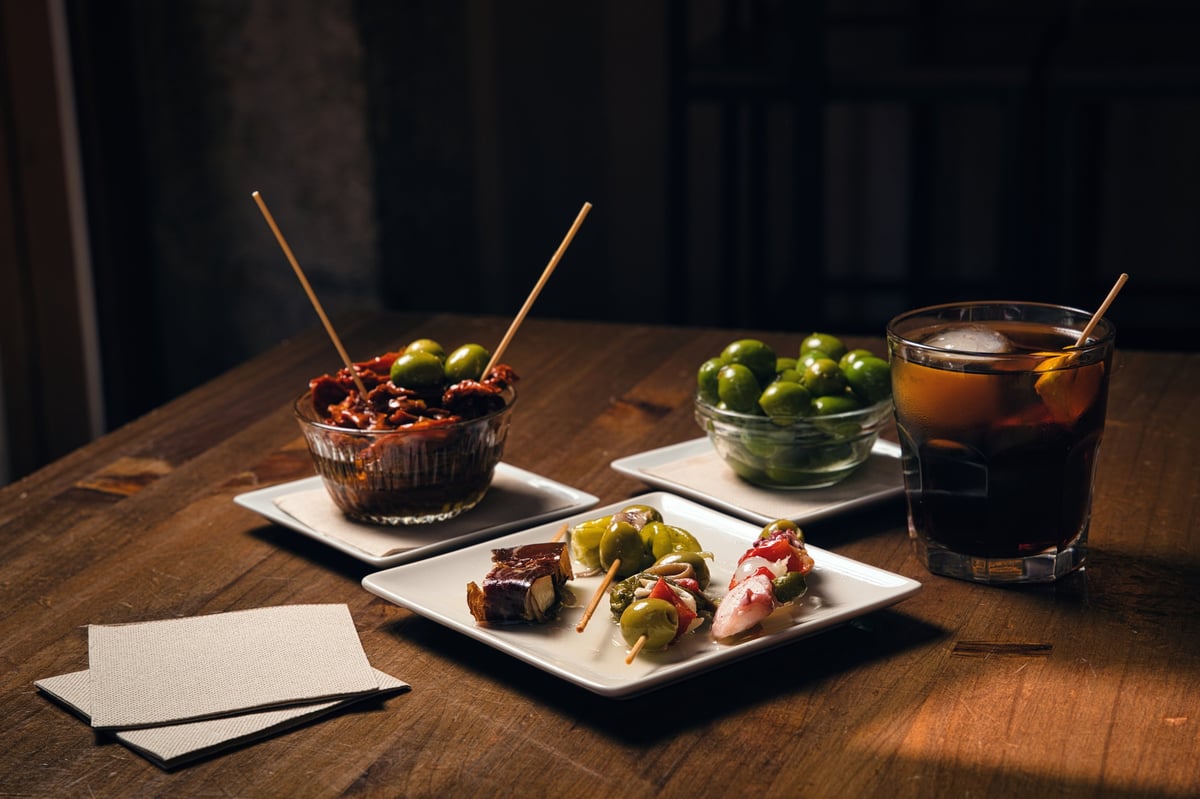 Verrmut y tapas sobre la barra de CASA BRAVA con luz cálida