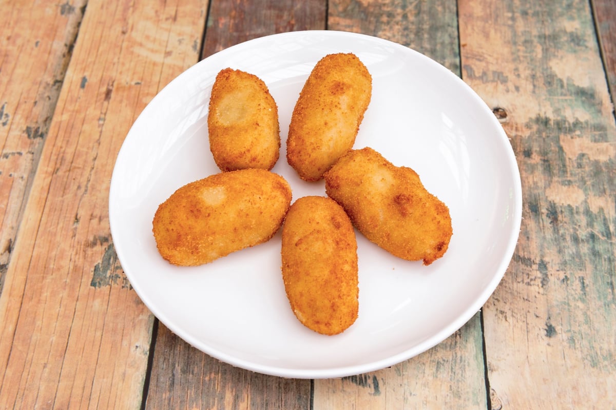 Croquetas de jamón doradas en plato de cerámica