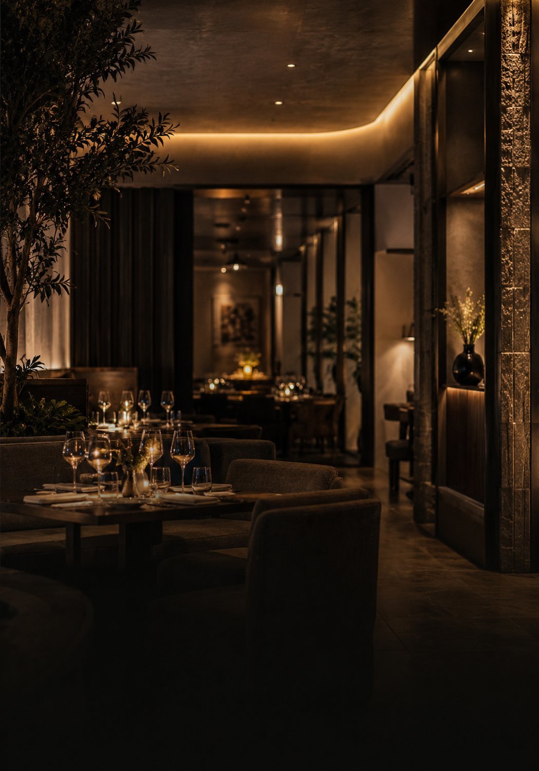Upscale restaurant interior with warm ambient lighting, round table with glasses, dark curtains and elegant modern design